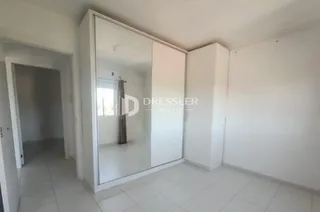 Interior de um ambiente com paredes brancas e piso de cerâmica.