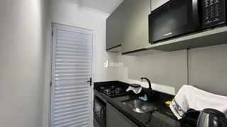 Vista da cozinha com armários e bancada escura.