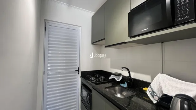 Vista da cozinha com armários e bancada escura.