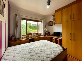 Quarto com cabeceira e armários de madeira em um imóvel no Brasil.