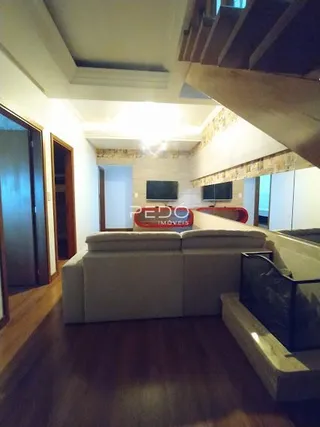 Foto de uma sala de estar com piso de madeira e vigas de madeira.