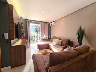 Sala de estar com sofá e painel de madeira em um imóvel no Brasil.