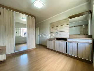 Ambiente interno com piso de madeira e painéis de madeira na sala.