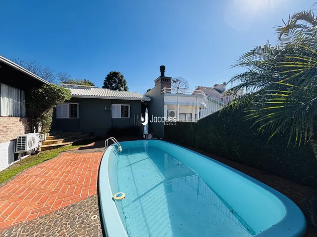 Vista da fachada de uma casa com piscina e pátio de tijolos em Lajeado.