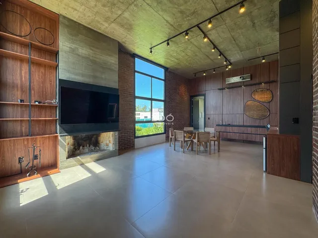 Sala de estar moderna com teto de concreto aparente e paredes de tijolo.