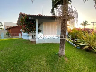 Foto da fachada de uma casa em Lajeado, Brasil, com gramado e vegetação.