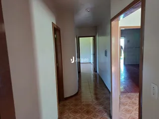 Vista de um corredor interno com piso de cerâmica.