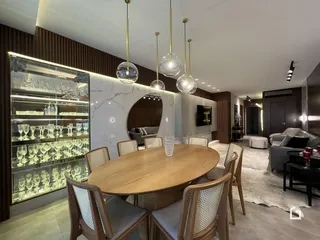 Sala de jantar com mesa de madeira e armário de vidro em um imóvel no Brasil.