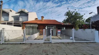 Fachada de uma residência em Lajeado, Brasil, com portão de ferro branco.