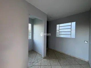 Vista de um corredor interno com piso de cerâmica e paredes brancas.