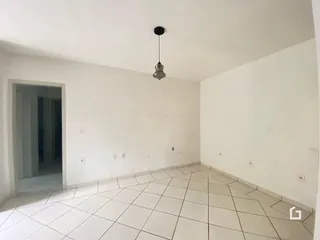 Ambiente interno com paredes brancas e piso de cerâmica.