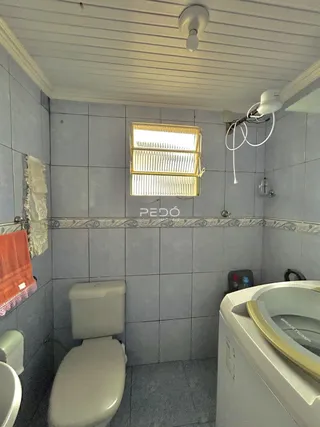 Foto de um banheiro com revestimento de azulejos cinzas.
