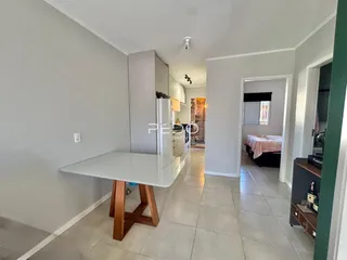 Cozinha moderna com piso de cerâmica clara e armários brancos.
