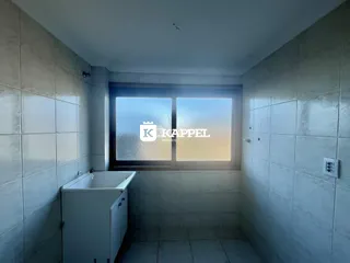 Banheiro com revestimento de azulejos brancos e janela.