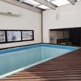 Foto da piscina externa com deck de madeira em uma residência.