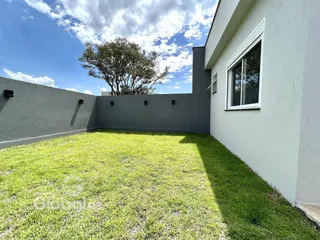 Vista da fachada de uma casa com jardim gramado.