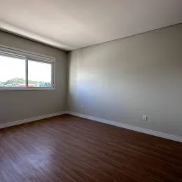 Ambiente interno com piso de madeira e janela.