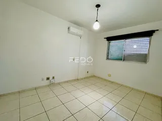 Ambiente interno de uma sala com piso de cerâmica e ar-condicionado instalado.