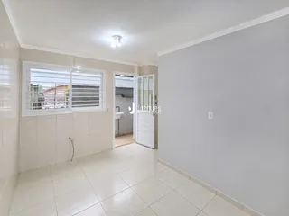 Hall de entrada com piso de cerâmica e janela na parede esquerda.