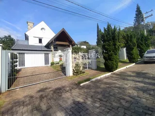 Fachada de uma residência em Lajeado, Brasil, com portão e muro.