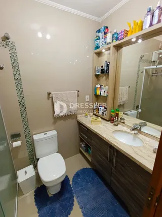 Foto de um banheiro interno com revestimento cerâmico e louças sanitárias.