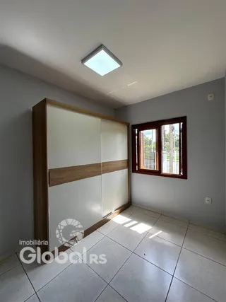 Quarto com armários embutidos e janela de madeira.