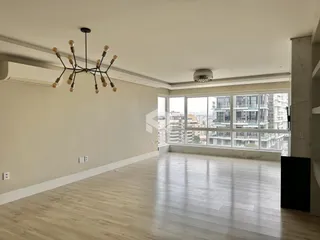 Sala ampla com piso de madeira e grande janela.