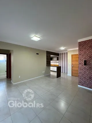Ambiente interno de uma sala com piso de cerâmica e parede de tijolo aparente.
