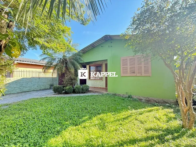 Fachada de uma casa verde com jardim em Lajeado, Brasil.
