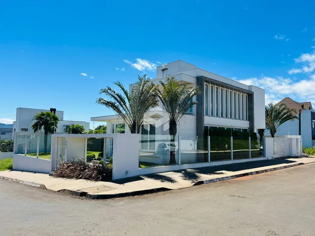 Fachada moderna de uma residência em Lajeado, Brasil, com grandes janelas de vidro.