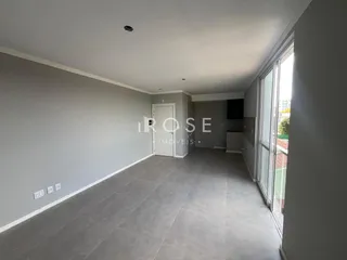 Interior de um corredor com piso de cerâmica cinza e paredes cinzas
