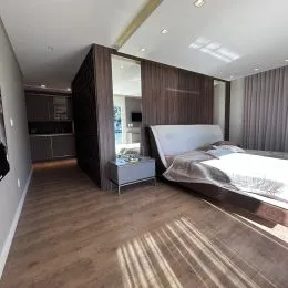 Quarto com piso de madeira e cama grande em um imóvel.