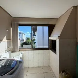 Foto de um cômodo interno com piso de azulejo claro e janela.