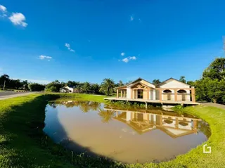 Vista externa de uma casa refletida em uma água ao ar livre.