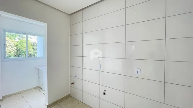 Parede interna com revestimento cerâmico claro em um imóvel.