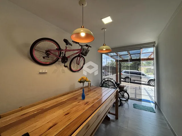 Uma sala de jantar com mesa de madeira e uma bicicleta na parede.