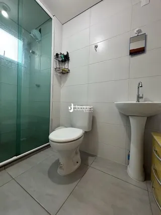 Foto de um banheiro com piso de cerâmica e box de vidro.