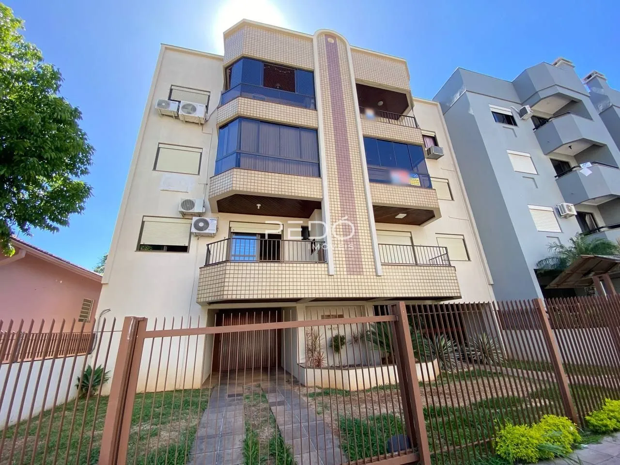Fachada de um prédio residencial em Lajeado, Brasil, com varandas e cerca de ferro.