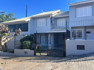 Fachada de uma residência em Lajeado, Brasil, com muro e portão de ferro.