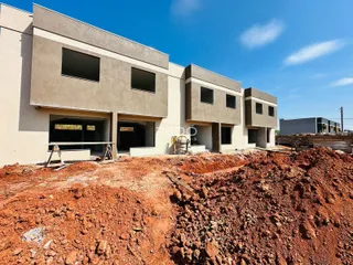 Fachada de um prédio em construção em Lajeado, Brasil, com terra exposta no primeiro plano.