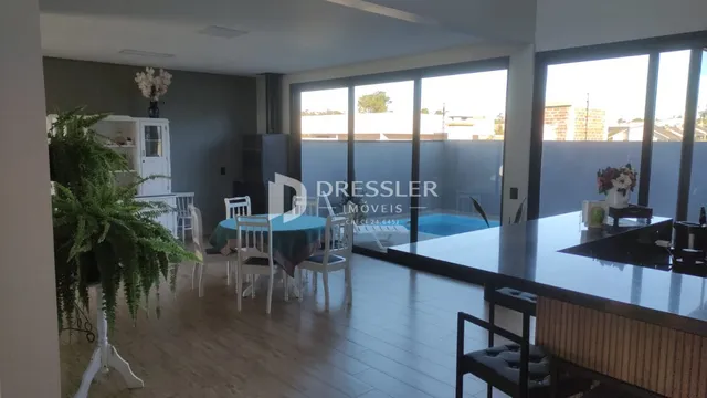 Sala de estar com piso de madeira e portas de vidro que dão para o exterior.
