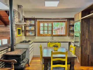 Imagem de uma cozinha com piso de madeira e armários brancos.