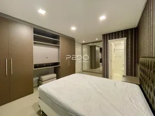 Quarto com armários embutidos e cabeceira de cama.