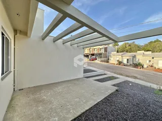 Fachada de uma residência com estrutura moderna e pátio de concreto.