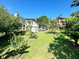 Vista externa de um jardim com gramado verde e vegetação em uma propriedade em Lajeado.