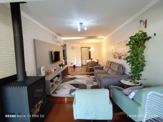 Sala de estar com piso de madeira e lareira em um imóvel no Brasil.