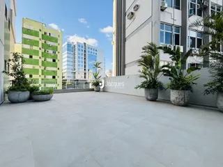 Área externa pavimentada entre dois edifícios residenciais.