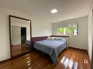 A foto mostra um quarto com piso de madeira e uma cama.