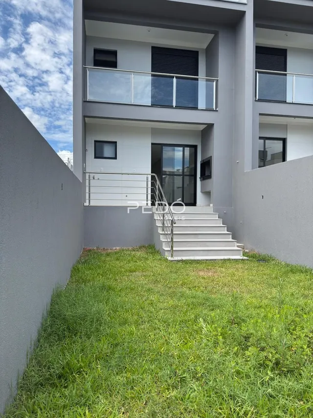 Fachada de um prédio residencial em Lajeado, Brasil, com varandas e gramado na frente.
