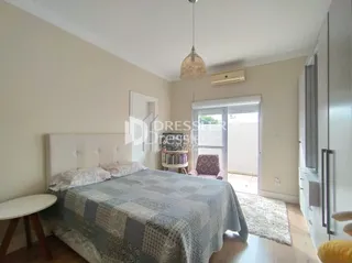 Quarto com cama de casal e janela.